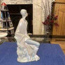Elegant sitting boy figurine made by Nao in Spain