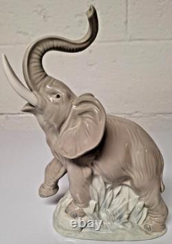 Grey elephant figure. Lladro NAO Spain porcelain, trunk, foot raised. 8.5 high