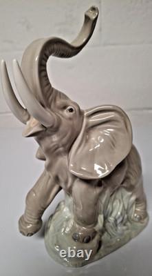 Grey elephant figure. Lladro NAO Spain porcelain, trunk, foot raised. 8.5 high