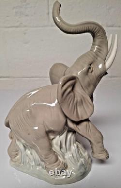Grey elephant figure. Lladro NAO Spain porcelain, trunk, foot raised. 8.5 high