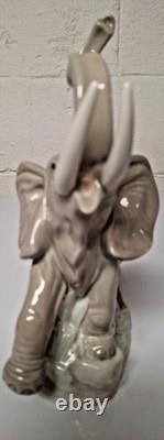 Grey elephant figure. Lladro NAO Spain porcelain, trunk, foot raised. 8.5 high