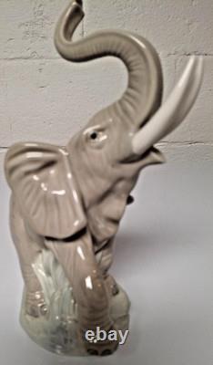 Grey elephant figure. Lladro NAO Spain porcelain, trunk, foot raised. 8.5 high