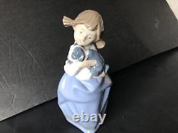 Lladro Nao girl with pigtals holding her puppy. Excellent condition. 7in. Tall