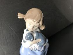 Lladro Nao girl with pigtals holding her puppy. Excellent condition. 7in. Tall