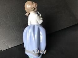 Lladro Nao girl with pigtals holding her puppy. Excellent condition. 7in. Tall