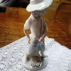 Lladró (Nao) porcelain sculpture of a boy playing slingshot, wearing a straw ha