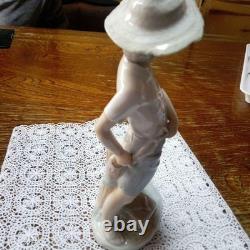 Lladró (Nao) porcelain sculpture of a boy playing slingshot, wearing a straw ha