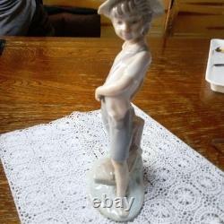 Lladró (Nao) porcelain sculpture of a boy playing slingshot, wearing a straw ha
