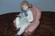 Nao By Lladro 15 CM Pig Tail Girl Sitting In A Pink Armchair Playing With A Doll