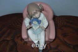 Nao By Lladro 15 CM Pig Tail Girl Sitting In A Pink Armchair Playing With A Doll