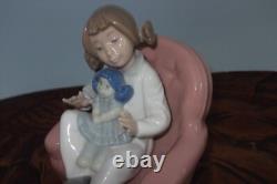 Nao By Lladro 15 CM Pig Tail Girl Sitting In A Pink Armchair Playing With A Doll