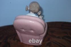 Nao By Lladro 15 CM Pig Tail Girl Sitting In A Pink Armchair Playing With A Doll