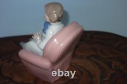 Nao By Lladro 15 CM Pig Tail Girl Sitting In A Pink Armchair Playing With A Doll