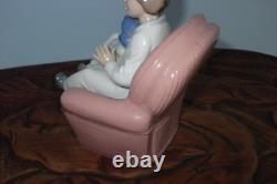 Nao By Lladro 15 CM Pig Tail Girl Sitting In A Pink Armchair Playing With A Doll