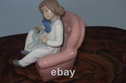 Nao By Lladro 15 CM Pig Tail Girl Sitting In A Pink Armchair Playing With A Doll