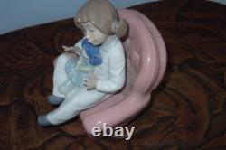 Nao By Lladro 15 CM Pig Tail Girl Sitting In A Pink Armchair Playing With A Doll